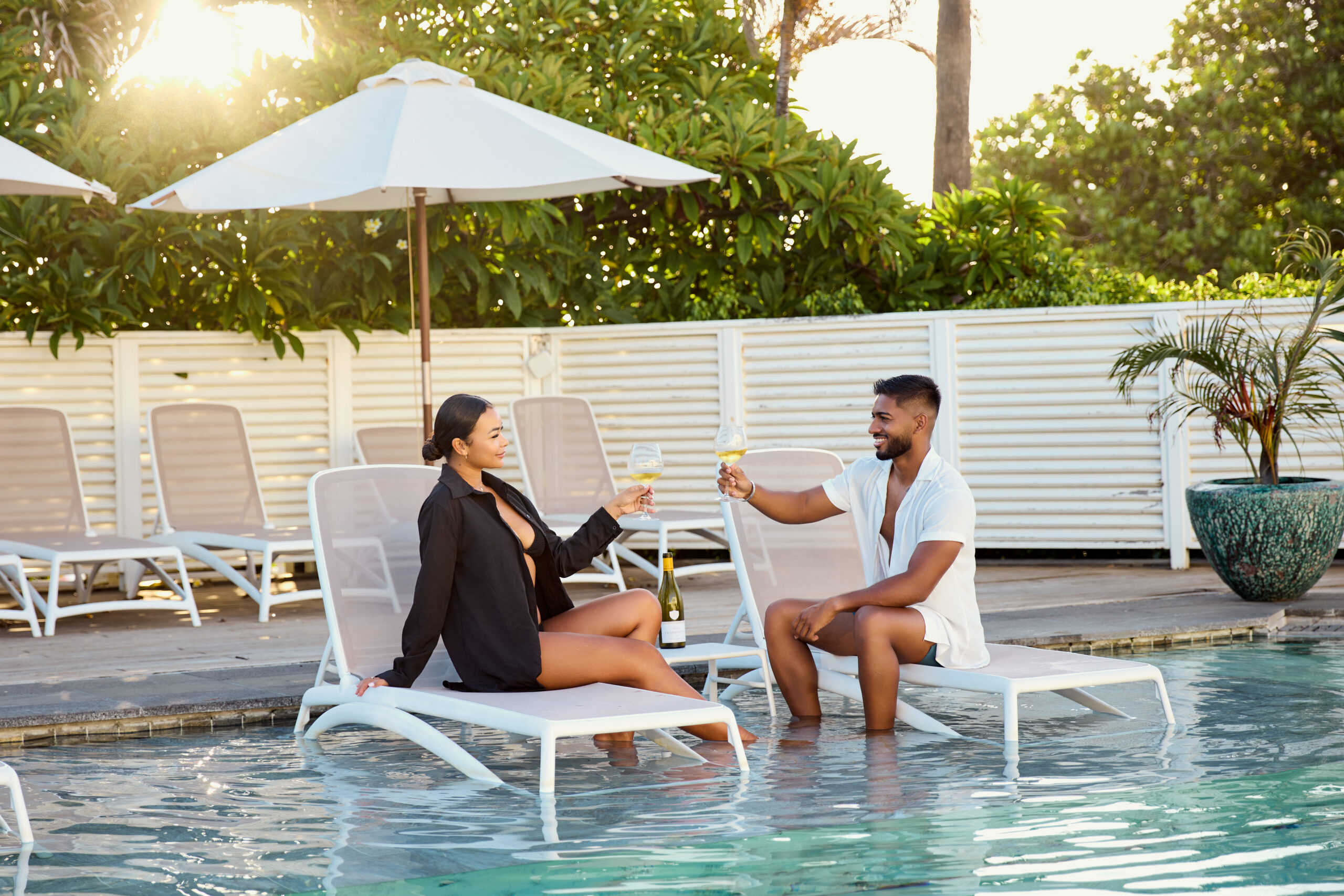 Couple au bord de la piscine du restaurant la voile blanche sirotant un cocktail