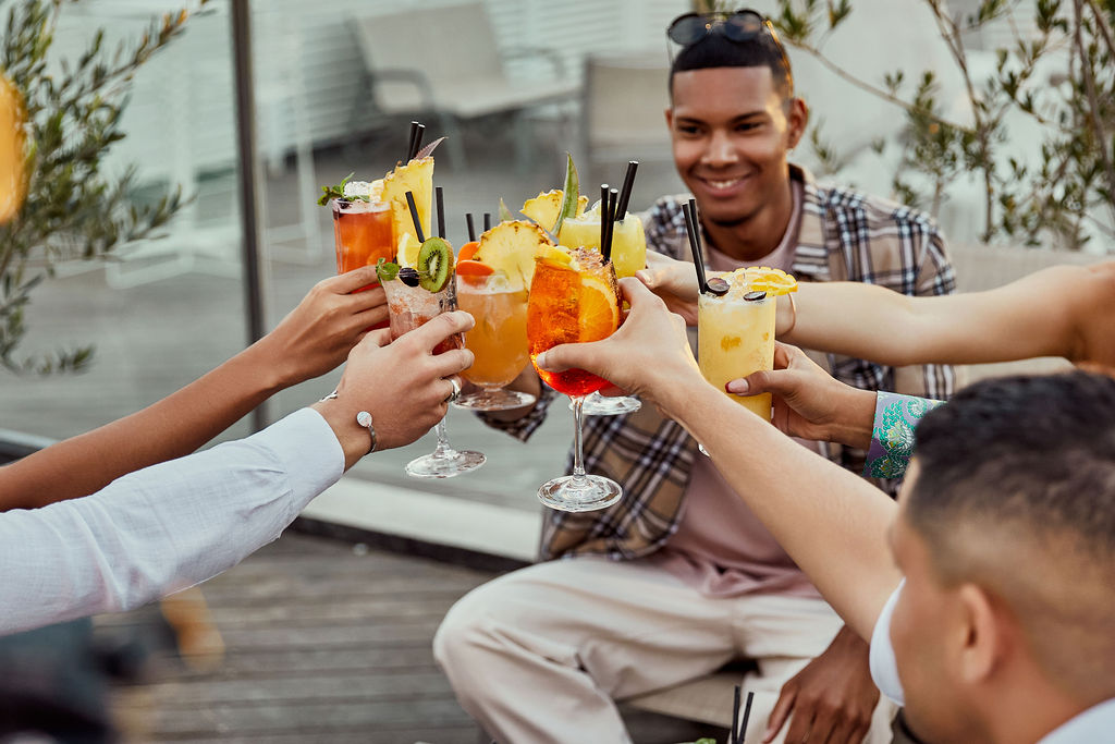 Amis portant un toast avec des cocktails au bord de la piscine de l'hôtel sur Saint-Pierre de la Réunion